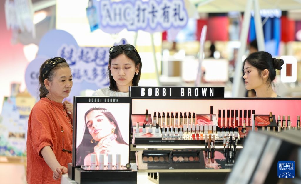 海口日月广场免税店芭比波朗柜台，三位顾客在看彩妆