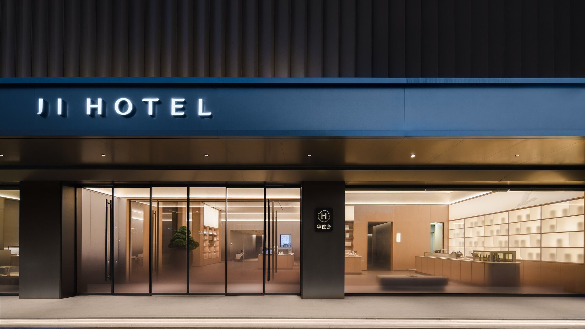 全季酒店上海吴中路店门头夜景，蓝色 JI HOTEL 招牌，玻璃门内是大堂